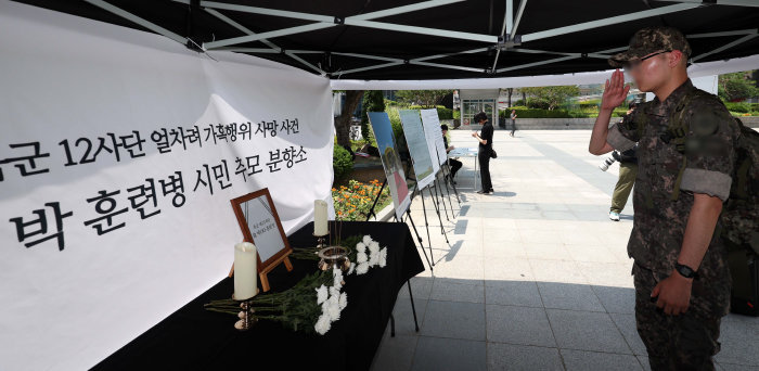 한 군장병이 6월 19일 서울 용산역 광장에 마련된 가혹 행위로 사망한 육군 12사단 신병교육대 훈련병의 추모분향소에서 고인을 추모하고 있다. [뉴시스]