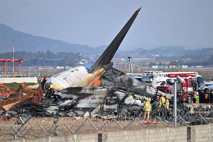 전남 무안공항에서 여객기 착륙 도중 충돌 사고가 난 29일 오후 소방 당국이 여객기 잔해를 살피고 있다. 뉴시스