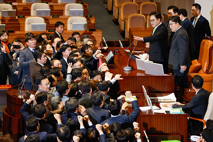 12월 27일 국회 본회의에서 우원식 국회의장이 한덕수 대통령 권한대행 탄핵안 표결 의결 정족수를 ‘재적 과반’으로 선언하자 국민의힘 의원들이 의장석으로 몰려가 항의하고 있다. [뉴스1]