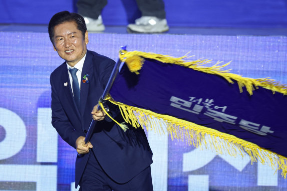 정청래 더불어민주당 신임 당대표가 8월 2일 경기 고양시 킨텍스에서 열린 제2차 임시전국당원대회에서 당기를 흔들고 있다. 뉴스1 