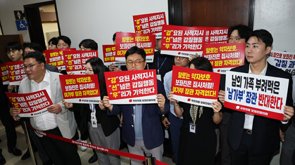 국민의힘 보좌진협의회 소속 보좌관이 7월 14일 서울 여의도 국회에서 열리는 강선우 여성가족부 장관 후보자 인사청문회장 앞에서 규탄하는 손팻말을 들고 있다. 뉴스1