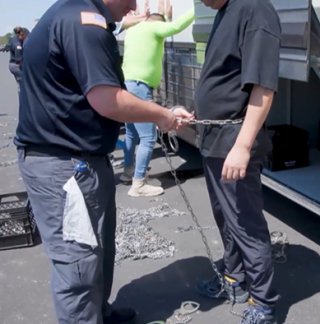 9월 4일(현지 시각) 미국 조지아주 현대차그룹-LG에너지솔루션의 합작 배터리 공장 현장에서 한 한국인 근로자가 허리에 쇠사슬이 감기고 있다. 미국 이민세관단속국 홈페이지 캡처