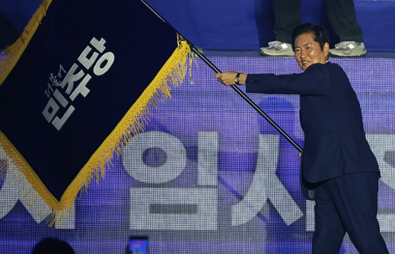 정청래 더불어민주당 대표가 8월 2일 오후 고양 킨텍스에서 열린 더불어민주당 전국당원대회(전당대회)에서 당선 후 당기를 흔들고 있다. 동아DB