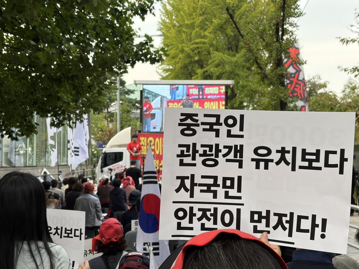 9월 30일 서울 여의도 국회의사당역 인근에서 열린 ‘중국인 무비자 입국 반대 집회’에서 한 참가자가 피켓을 들고 있다. 뉴스1