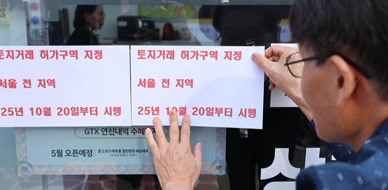 서울 전역과 경기도 12개 지역에서 토지거래허가제가 본격 시행된 10월 20일 서울 은평구 대조동의 한 공인중개소 중개인이 안내문을 유리에 붙이고 있다. 동아DB