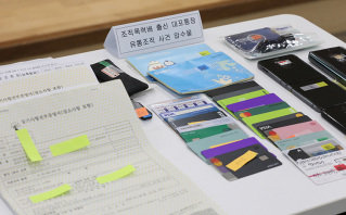 2023년 1월 17일 서울동부지방검찰청이 보이스피싱 사기범죄에 사용된 대포통장과 출금카드, 대포폰을 압수해 보여주고 있다. 뉴시스