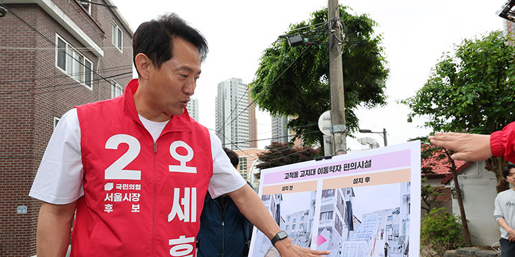 오세훈 국민의힘 서울시장 후보가 5월 11일 서울 구로구 고척동 고지대 이동편의시설 설치 대상지를 찾아 사업 설명을 듣고 있다. 뉴시스