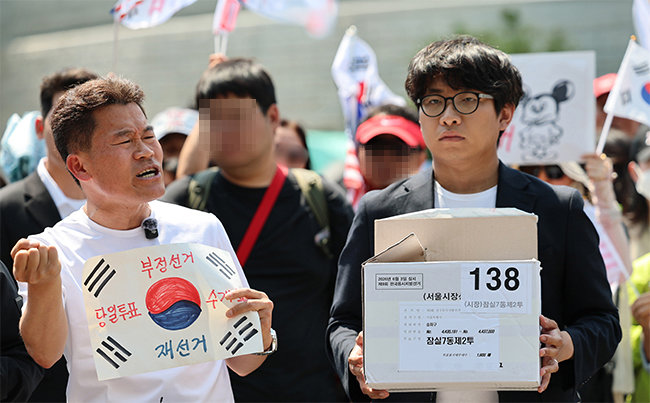 한국사 강사 출신 유튜버 전한길 씨가 6월 12일 서울 송파구 올림픽공원 핸드볼경기장에서 긴급 기자회견을 열고 선거관리위원회가 폐기했다고 밝힌 잠실7동 제2투표소 투표용지 보관상자 추정 물품을 공개하고 있다. 뉴스1