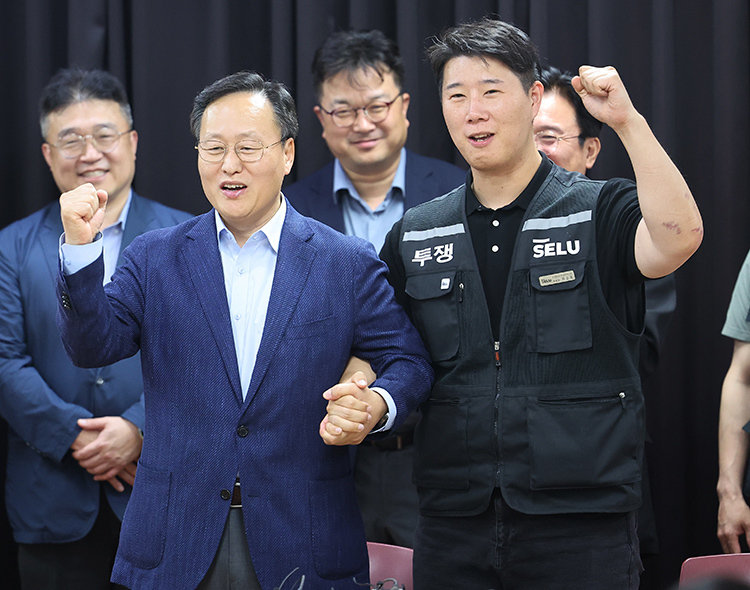5월 20일 경기 수원시 경기지방고용노동청에서 삼성전자 노사가 2026년 임금협약 잠정 합의안에 서명한 뒤 여명구 삼성전자 DS부문 피플팀장(부사장·앞줄 왼쪽)과 최승호 삼성 초기업노조 삼성전자지부 위원장이 한 손을 맞잡고 파이팅을 외치고 있다. 삼성전자 노사는 지난해 12월 16일 본교섭을 시작한 지 156일 만에 총파업 직전 임금협약 잠정 합의안을 이끌어냈다. 동아DB