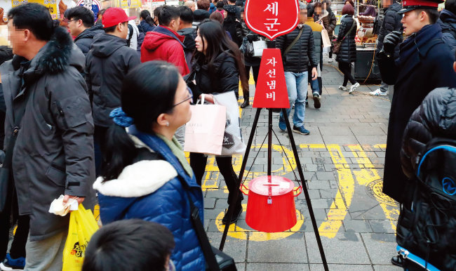 서울 중구 명동거리의 구세군 자선냄비. 많은 시민이 자선냄비를 지나치고 있다. [동아일보]