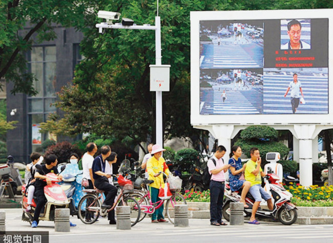 중국 후베이성 샹양시 건널목에서 무단횡단한 주민의 모습이 대형 전광판에 뜨고 있다. [VCG]