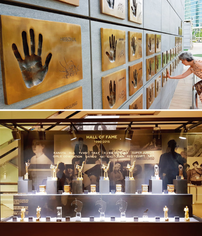  건물 밖에 있는 SM 소속 아티스트들의 손바닥.(위) 1996년부터 2015년까지 아티스트들이 받은 연말 시상식 트로피. [구희언 기자]