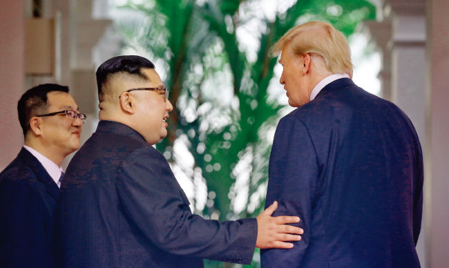 김정은 북한 국무위원장이 6월 12일 싱가포르 북·미 정상회담에서 처음 대면한 도널드 트럼프 미국 대통령의 왼팔을 잡고 친근감을 표시하고 있다. [사진 제공 · 싱가포르 정부]