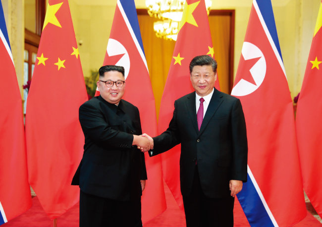 6월 19일 중국 베이징에서 김정은 북한 국무위원장이 시진핑 국가주석과 악수하고 있다. [뉴시스]
