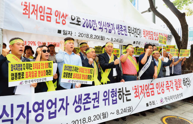 한국외식업중앙회 회원들이 8월 20일 오후 서울 종로구 광화문광장 인근에서 최저임금 인상 규탄 집회를 열고 자영업자 생계 대책 마련을 촉구하는 구호를 외치고 있다 [뉴시스]