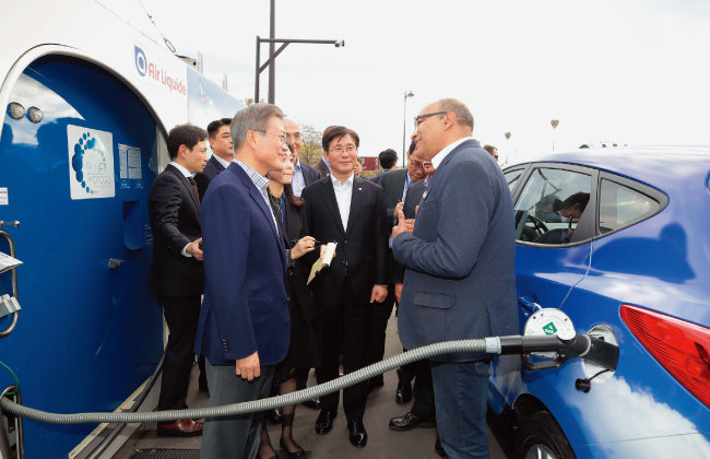 문재인 대통령이 10월 14일 프랑스 파리 도심의 수소충전소를 방문해 현대차의 수소전지차 ‘투싼’을 운전하는 택시기사와 대화를 나누고 있다. [뉴시스]