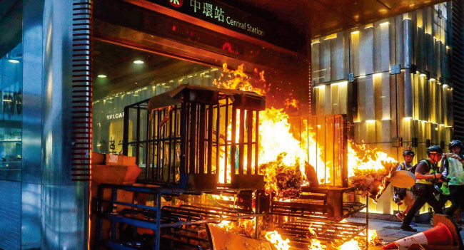 홍콩 금융산업의 상징인 센트럴 지하철역 입구가 시위대의 방화로 불타고 있다. [SCMP]