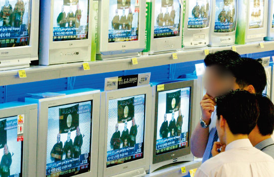 2004년 6월 21일 서울역 인근 한 대형할인점에서 김선일씨 납치법들이 보낸 테이프가 TV를 통해 방영되자 시민들이 심각한 표정으로 지켜보고 있다. [원대연 동아일보 기자]