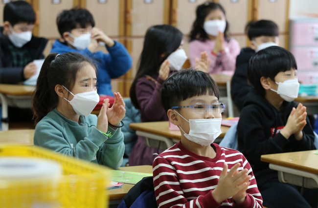 지난 2월 초 서울 시내 한 초등학교에서 학생들이 마스크를 쓴 채 교실에 앉아 있다. [뉴스1]