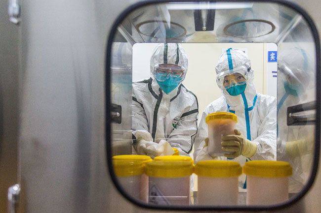 지난 2월 중국 베이징의 중국질병통제예방센터 연구실에서 직원들이 신종 코로나바이러스 변종을 검사하고 있다. [신화=뉴시스]