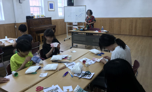 서울 용산구에 있는 H아동복지시설 봉사자가 아이들과 함께 인형 만들기를 하고 있다.  [H아동복지시설 제공] 