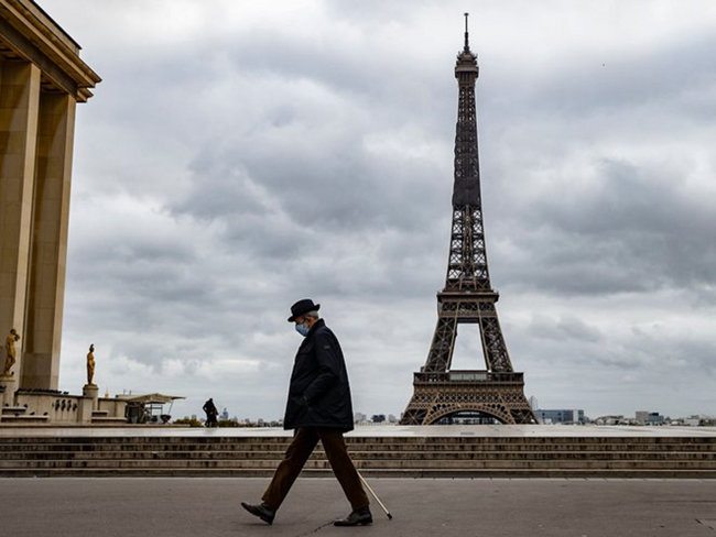 한 파리 시민이 프랑스 정부의 봉쇄조치로 폐쇄된 에펠탑 앞으로 지나고 있다. [EPA]