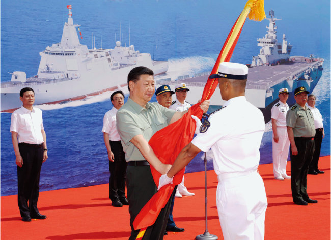 지난해 4월 23일 시진핑 중국 국가주석이 하이난성의 한 해군기지에서 열린 신형 함정 취역식에
참석해 함장에게 군기를 전달하고 있다. [뉴시스]