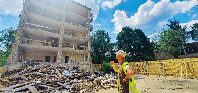 6월 9일 우크라이나 수도 키이우의 파괴된 아파트를 시 관계자가 점검하고 있다.