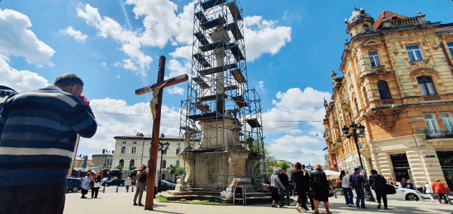 5월 15일 르비우 중심가에 설치되고 있던 ‘십자가에 달린 예수상’ 앞에서 시민들이 기도하고 있다.