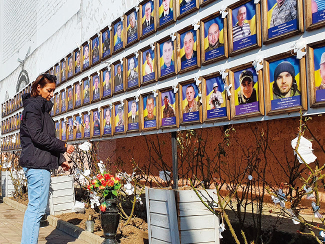 3월 29일 우크라이나 서부 체르니우치 시청 광장에서 한 시민이 이 지역 출신 전사자들을 추모하고 있다.