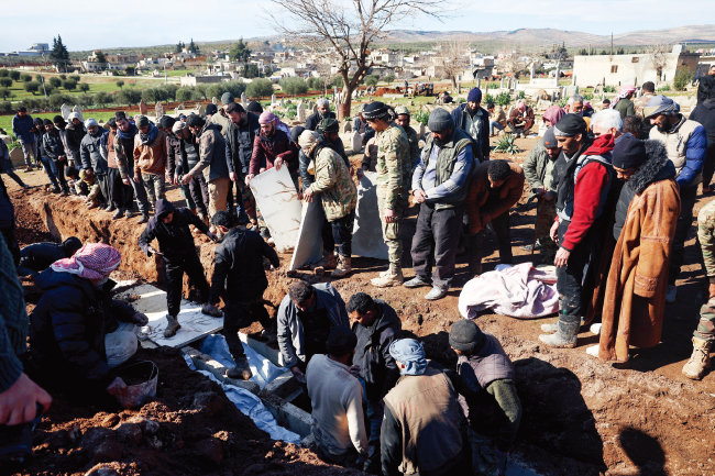 튀르키예 지진 발생 이틀째인 2월 7일(이하 현지 시간) 시리아 북부 진데리스에서 주민들과 유가족들이 희생자 시신을 매장하고 있다. [뉴시스]