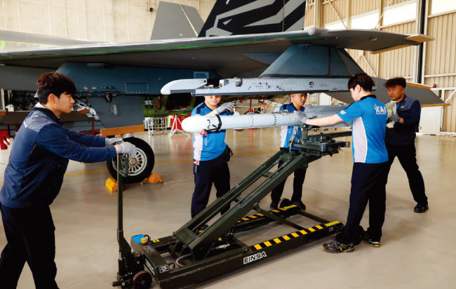 경남 사천시 한국항공우주산업(KAI) 본사 격납고에서 직원들이 KF-21 시제기에 미사일을 장착하고 있다. [뉴스1]