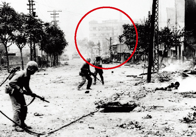1950년 9월 서울 탈환전에 나선 미국 해병대 병력 뒤편으로 충정아파트(원 안)가 보인다. [미국 해군 역사·유산 사령부 제공]