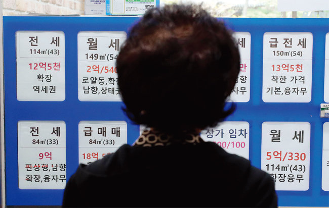 서울 송파구 한 부동산중개업소 앞에서 한 행인이 매물 가격을 들여다보고 있다. [뉴스1]
