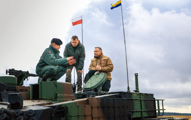 3월 31일(현지 시간) 폴란드 동북부 오르지스 훈련장에서 안제이 두다 대통령(오른쪽)과 마리우시 블라슈차크 부총리 겸 국방장관(가운데)이 한국산 K2 전차에 올라 설명을 듣고 있다. [폴란드 대통령실 제공]