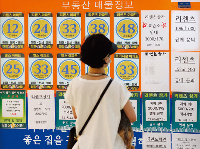 서울 시내 한 부동산공인중개사사무소 앞에서 시민이 아파트 시세를 보고 있다. [뉴스1]