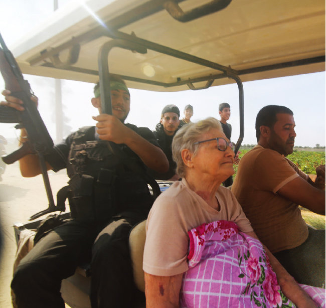 하마스 조직원들이 이스라엘 여성 노인을 납치하고 있다. [뉴시스]