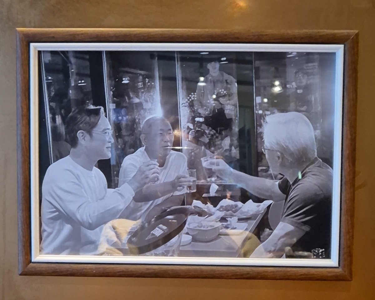 깐부치킨 삼성점 매장 벽면에 붙어 있는 사진. 젠슨 황 엔비디아 최고경영자(CEO)와 이재용 삼성전자 회장, 정의선 현대자동차그룹 회장(오른쪽부터 시계 방향으로)이 맥주잔을 든 모습이 담겨 있다. 임경진 기자