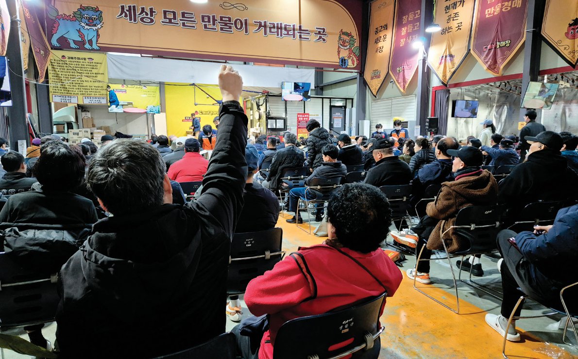 3월 2일 경기 용인시 처인구에 있는 ‘만물도깨비경매장’에 사람들이 몰린 가운데 한 손님이 물건을 사려고 손을 치켜들고 있다. 임경진 기자