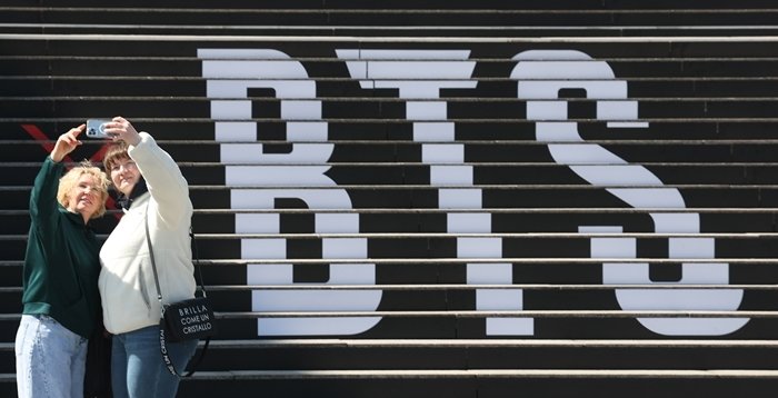 BTS의 광화문광장 공연을 일주일여 앞둔 3월 13일 서울 종로구 세종문화회관 계단을 장식한 BTS 로고 앞에서 외국인 관광객들이 사진을 찍고 있다. 동아DB