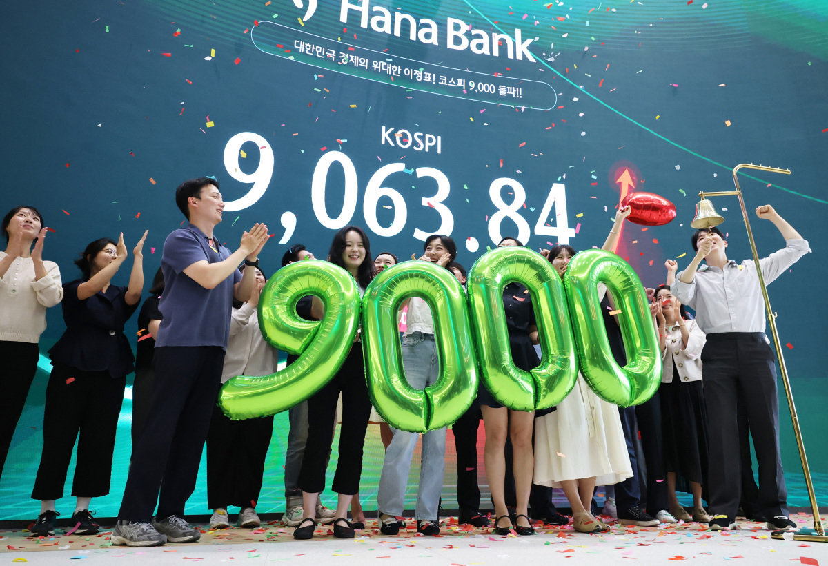 코스피가 사상 처음으로 9000을 돌파한 6월 18일 서울 중구 하나은행 딜링룸에서 직원들이 축하 세리머니를 하고 있다. 뉴스1