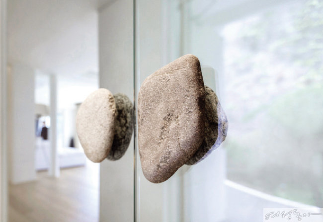 물성이 드러나는 돌로 손잡이를 마감한 현관 중문에서부터 고즈넉한 무드가 느껴진다.