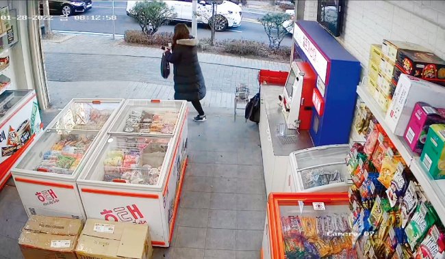 한 절도범이 무인점포에서 아이스크림 등을 훔친 뒤 가게를 빠져나가고 있다