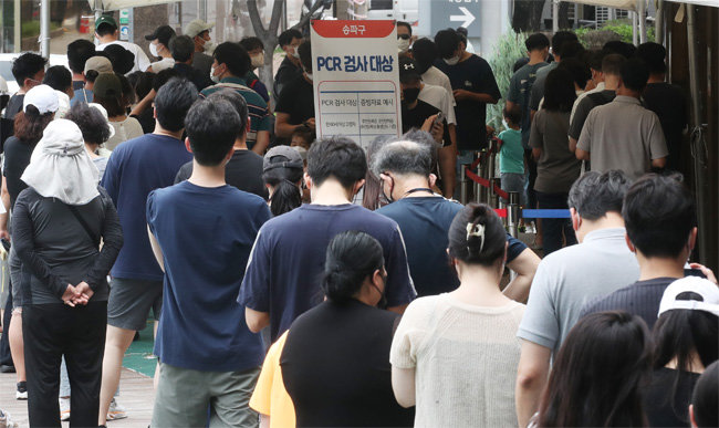 8월 15일 광복절 연휴에도 시민들이 코로나19 선별진료소 앞에서 길게 줄 서 있다.