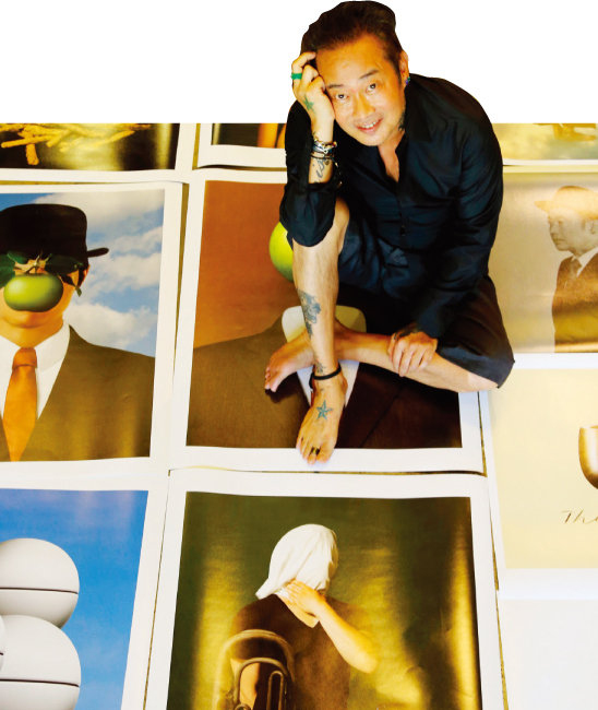 김중만 작가가 2011년 진행한 사진전 ‘이지적 우아함’에서 선보인 사진 견본 위에 앉아 미소 짓고 있다.