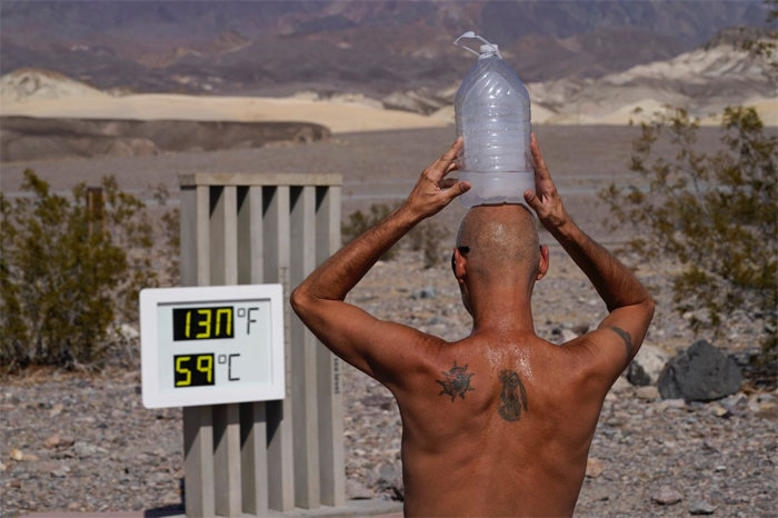 미국 캘리포니아주 데스밸리 국립공원에서 17일 한 남성이 머리에 얼음 물통을 올린 채 열을 식히고 있다. 이날 데스밸리의 기온은 섭씨 52.8도를 기록했다.