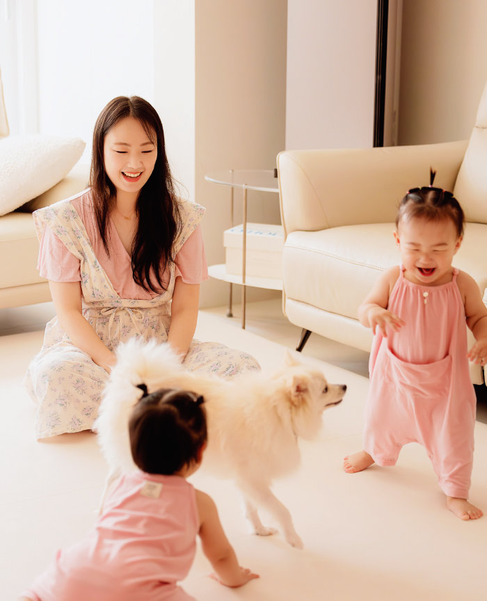 정홈 씨와 쌍둥이 두 딸이 반려견과 함께 거실에서 행복한 시간을 보내고 있다.