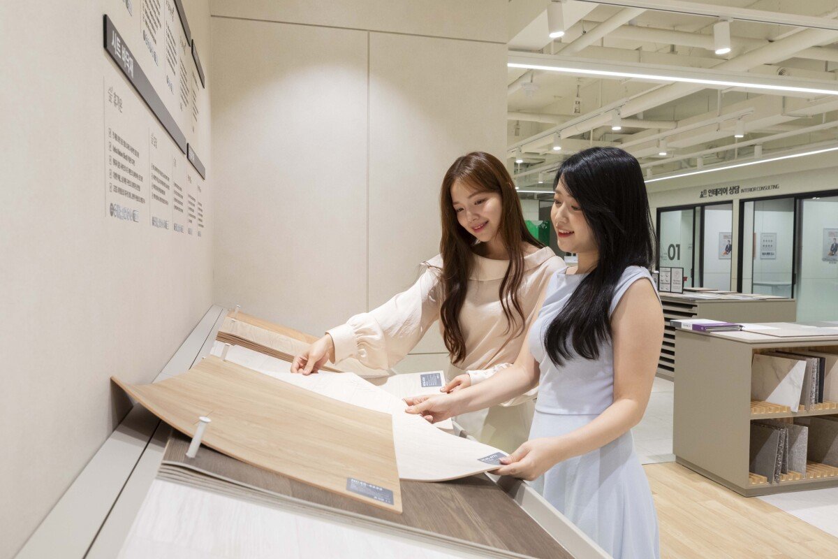 고객들이 KCC글라스 홈씨씨 전시장에서 다양한 바닥재 제품들을 살펴보고 있다.
