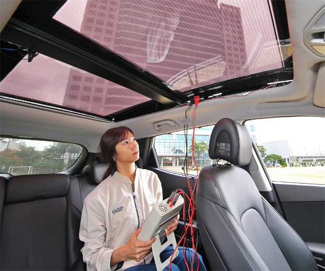 현대·기아자동차 연구원이 반투명으로 투광이 가능한 2세대 솔라루프가 설치된 자동차 안에서 솔라시스템 효율을 측정하고 있다. 현대자동차 제공
