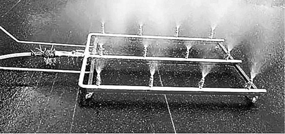 지난해 12월 전기차 화재 실험에 사용된 ‘상방향 방사장치’. 차량 아래로 바퀴 달린 분사장치를 투입해 물을 뿜으며 화재를 진압한다. 국립소방연구원 제공